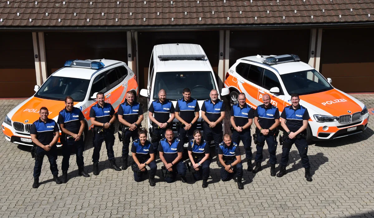 Polizisten des Korps Wetzikon haben sich vor drei Autos aufgestellt.